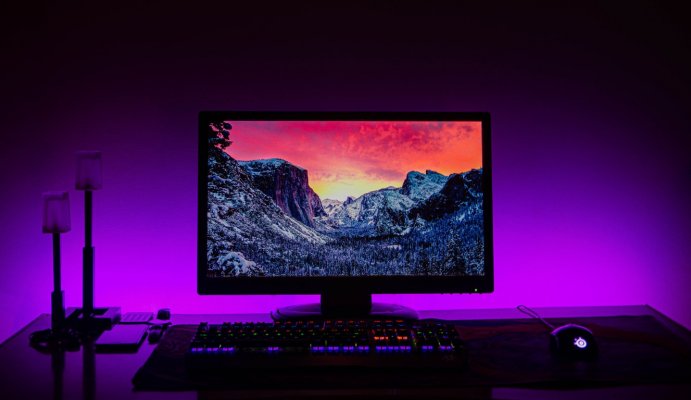 Desktop screen in dark room with blue and purple lights